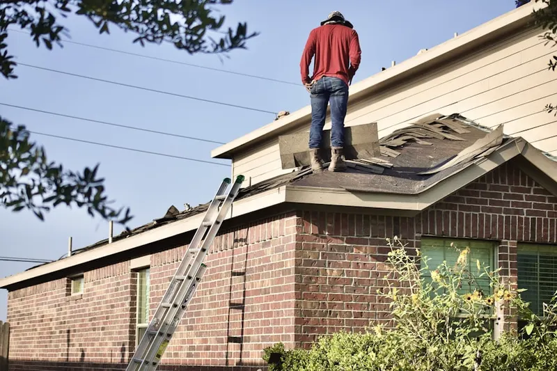 Professional roofer working on a residential roof in Holmes
